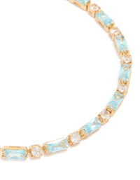 Showcasing a gold plated toggle bracelet with clear and aqua baguette cut cubic zirconia stones close up view - link has visual effect only