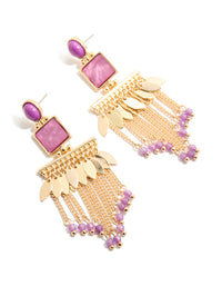Showcasing statement drop earrings in gold with purple oval stones, leaf charms and beaded chain tassels in front view - link has visual effect only