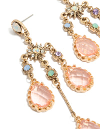 Crafted from gold with pink diamantes, these irregular long drop earrings showcase celestial charm details in close up view - link has visual effect only