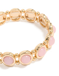 Featuring a beaded organic shaped stretch bracelet in gold and pink close up view - link has visual effect only