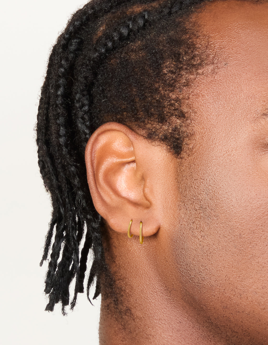 Featuring waterproof gold plated stainless steel mixed size sleeper hoop earrings in a 2-pack on ear view