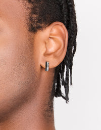 Featuring men's waterproof stainless steel huggie earrings with black enamel inlay in statement style on ear view - link has visual effect only