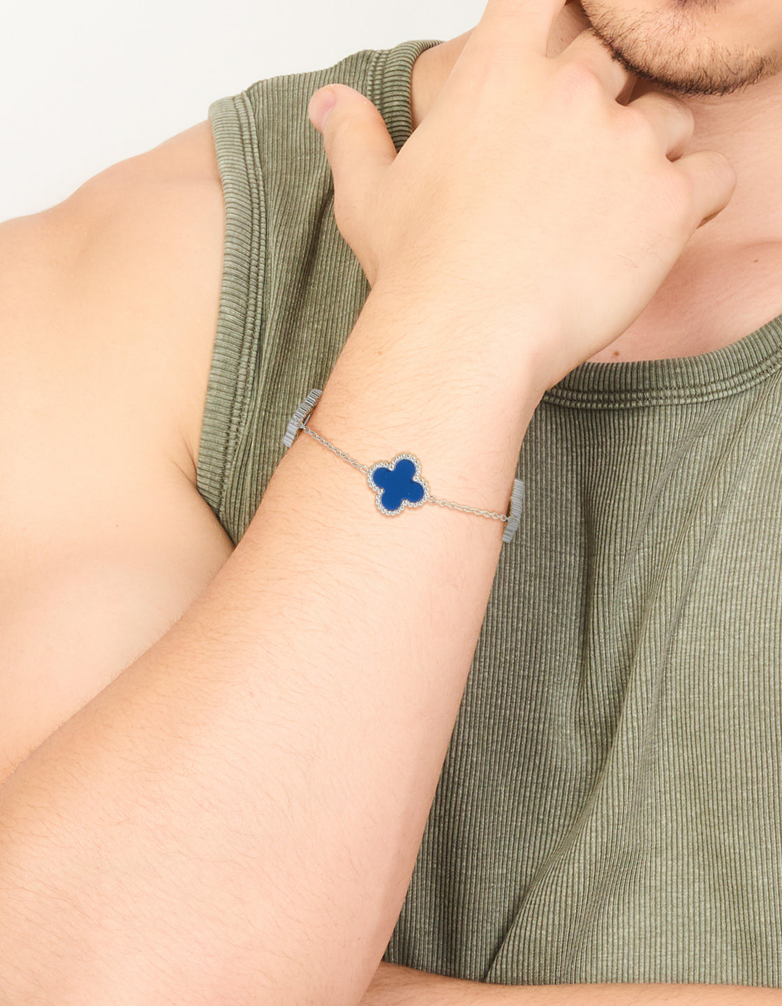 Showcasing a waterproof stainless steel men's navy clover chain bracelet with statement flower design in royal blue and silver on wrist view