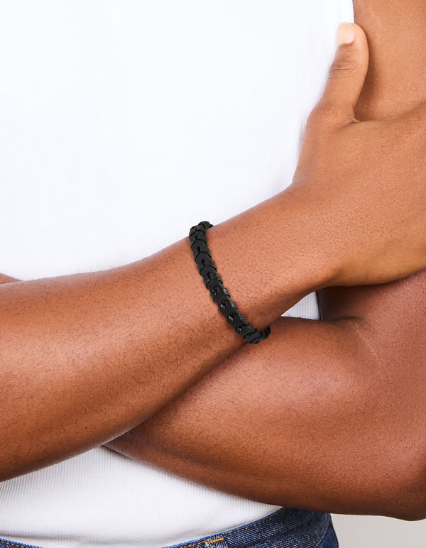 Featuring a mens waterproof black coated stainless steel and PU leather braided bracelet on wrist view