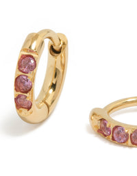 Showcasing waterproof gold plated stainless steel huggie earrings with pink cubic zirconia stones close up view - link has visual effect only
