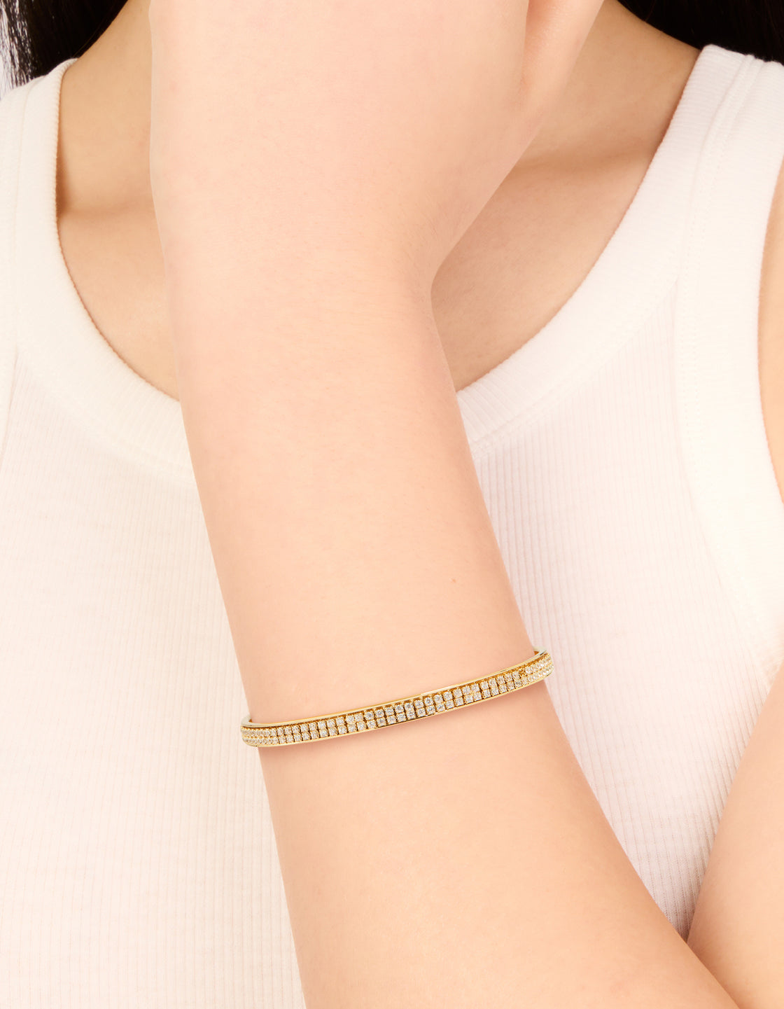 Showcasing a gold plated cubic zirconia flat bezel set wrist cuff on wrist view