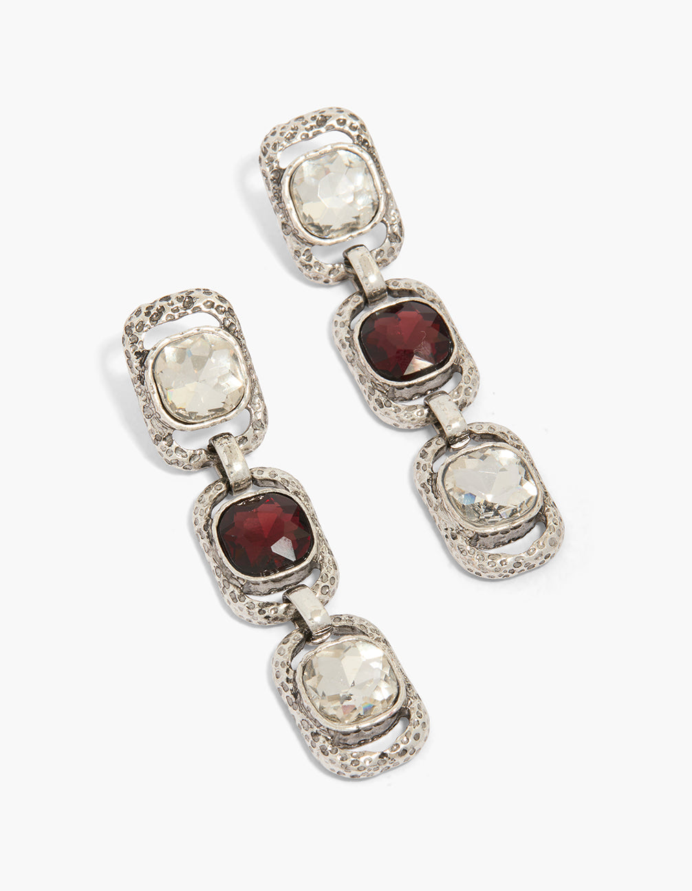 Showcasing chunky statement drop earrings in silver featuring burgundy and clear diamante stones front view