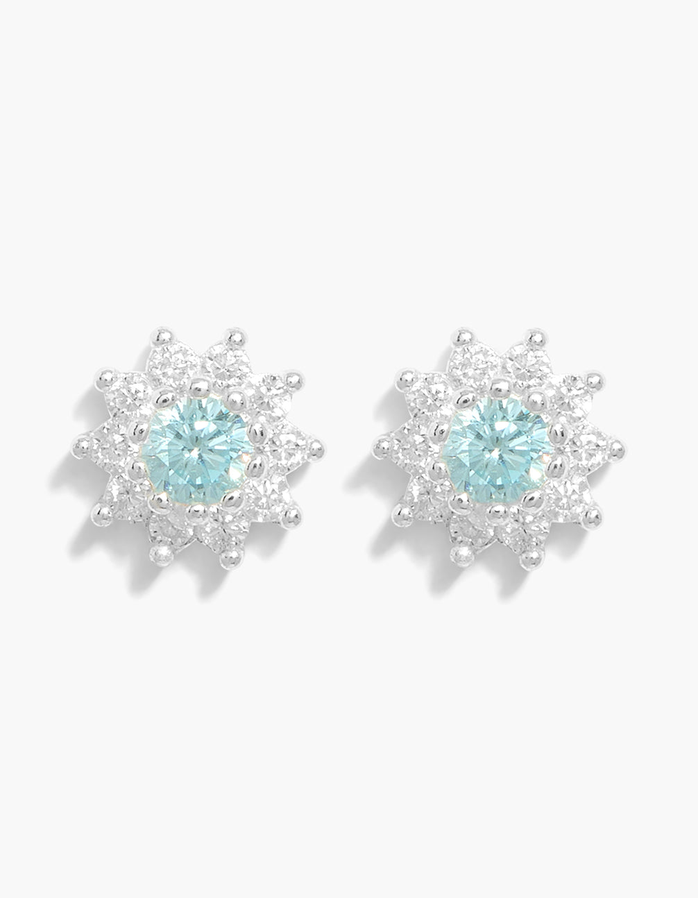 Showcasing sterling silver blue cubic zirconia halo stud earrings with pale turquoise center stones front view