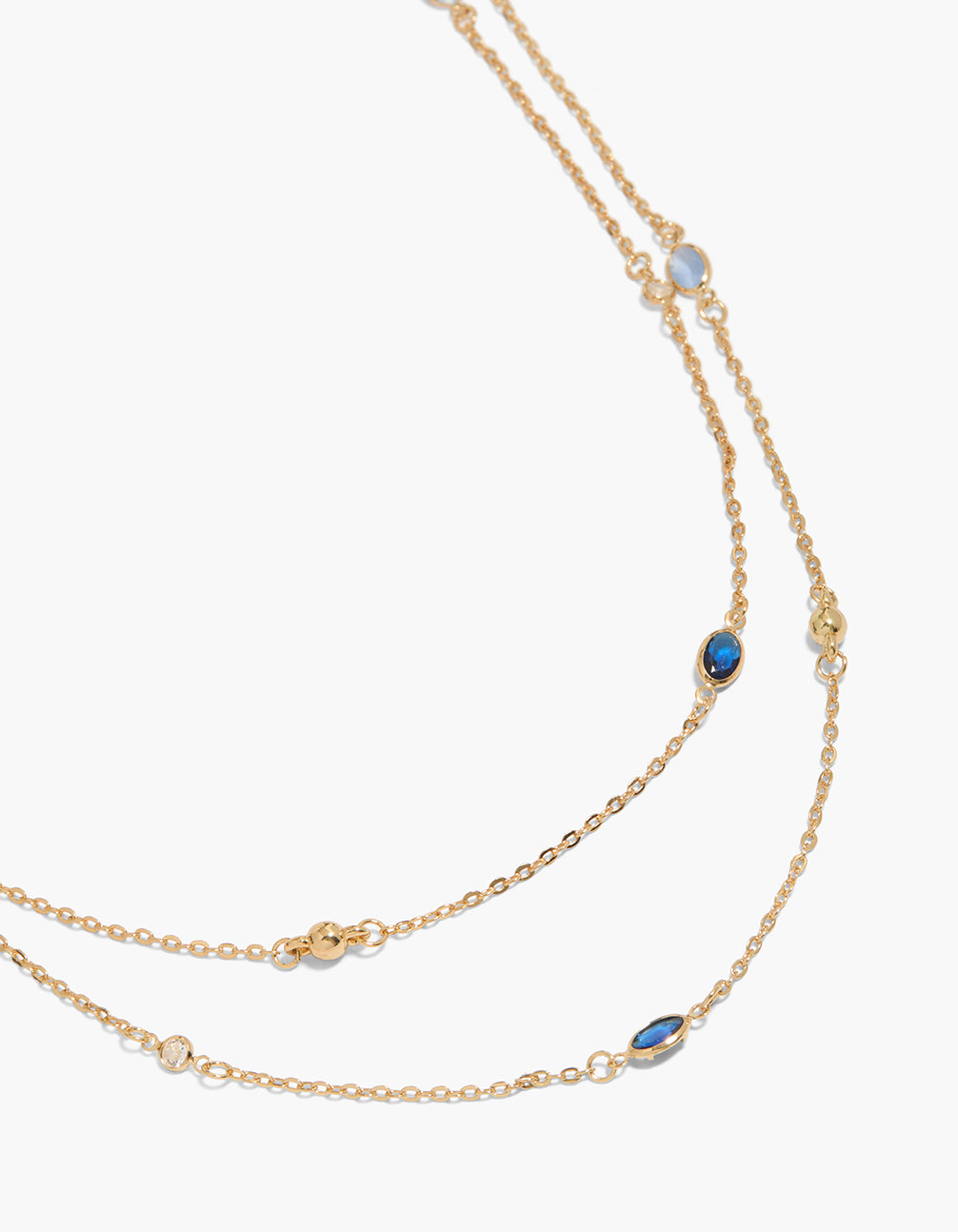 Showcasing a gold plated blue cubic zirconia long layered necklace with balls in dainty style close up view