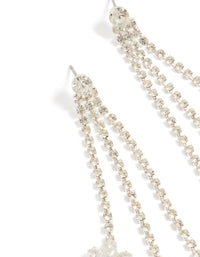 Highlighting silver diamante triple tassel drop earrings with floral accents in dainty style close up view - link has visual effect only