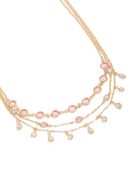 Featuring a gold pink diamantes triple layered necklace with charm detailing in a statement style close up view - link has visual effect only