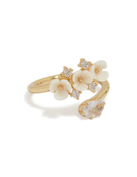 This statement ring showcases a gold plated wrap design featuring delicate floral with ivory petals and crystal accents front view - link has visual effect only