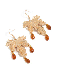 Featuring statement drop earrings with gold floral leaf design, orange beaded accents in front view - link has visual effect only