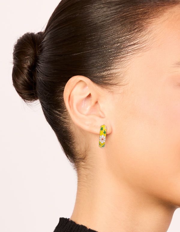 Discover huggie earrings with floral yellow enamel, pink flower and leaf prints in statement gold on ear view