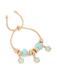 Showcasing a beaded charm bracelet with floral accents in gold and light blue front view - link has visual effect only