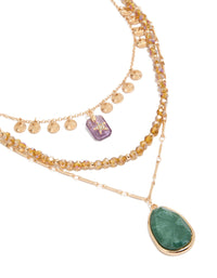 This gold celestial star, beaded chain layered necklace features charms, disc accents, pendant drops, and oval stone details in a close up view - link has visual effect only
