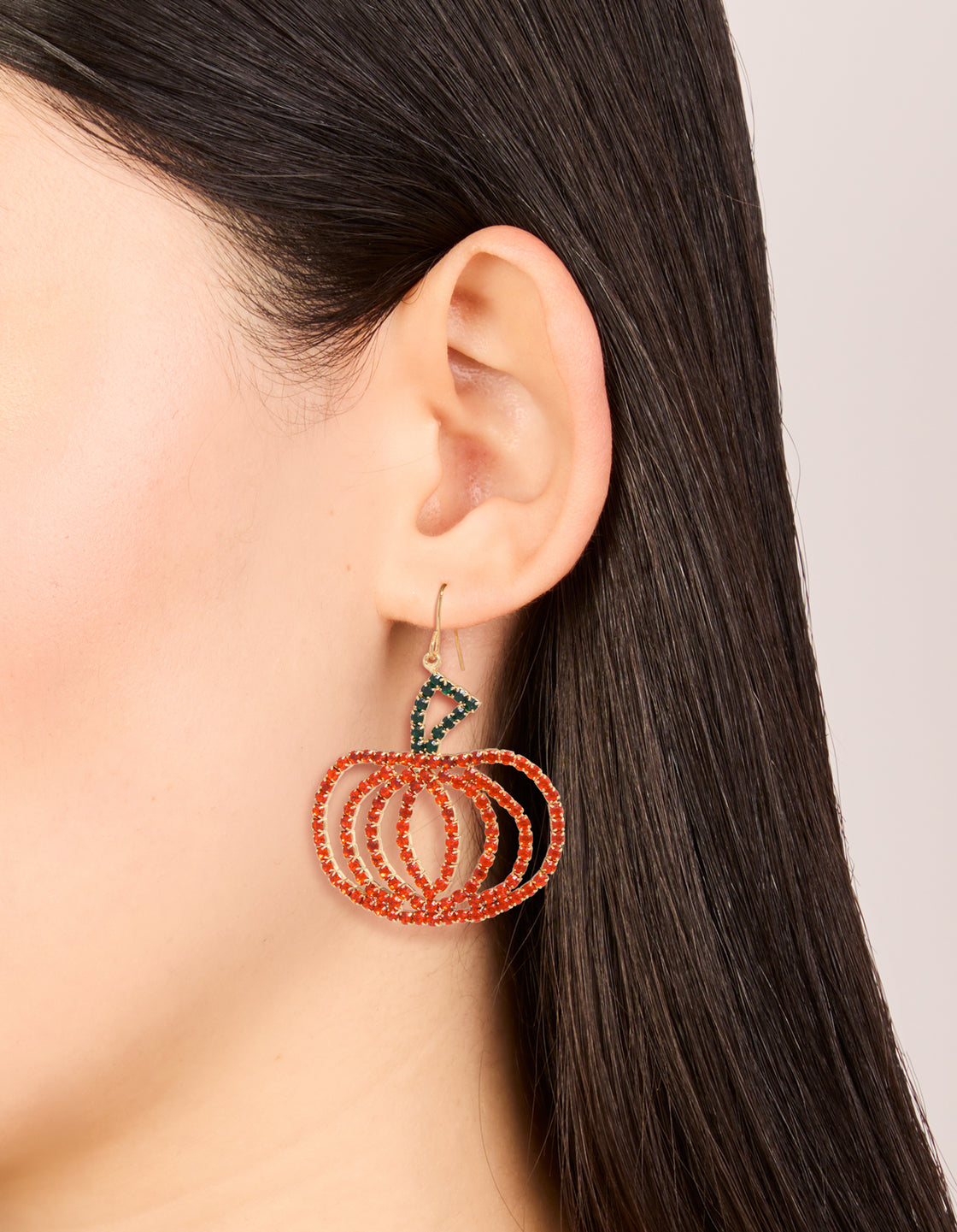 Showcasing chunky gold glam pumpkin drop earrings with food design in orange, dark green on ear view