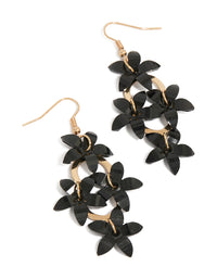Statement drop earrings featuring four black floral elements connected by gold circular links front view - link has visual effect only