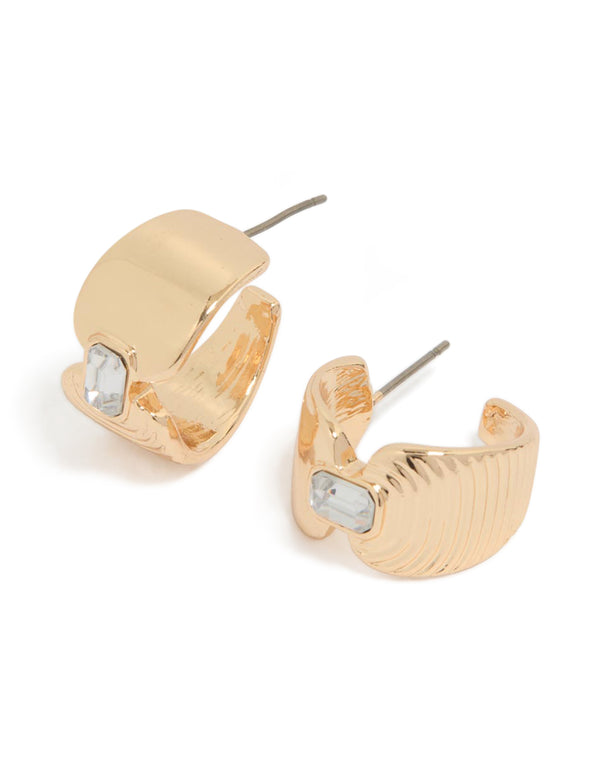 Elegant gold hourglass diamante huggie earrings featuring textured detailing and clear gemstone accents front view