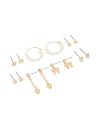 Showcasing a 7-pack of stud earrings featuring bow heart and pearl accents in gold front view - link has visual effect only
