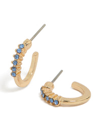 Showcasing gold light blue diamante row huggie earrings with huggie closure front view - link has visual effect only