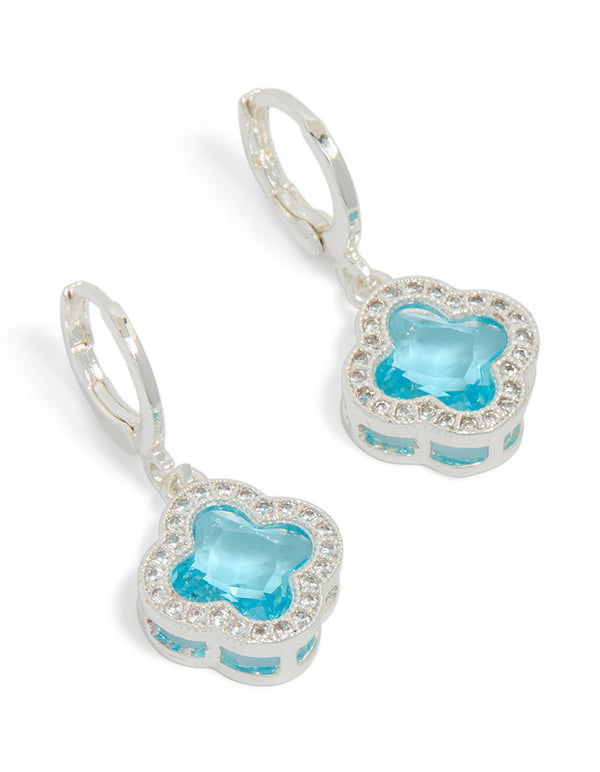Crafted from cubic zirconia, these blue and clear clover huggie earrings featuring floral in silver front view