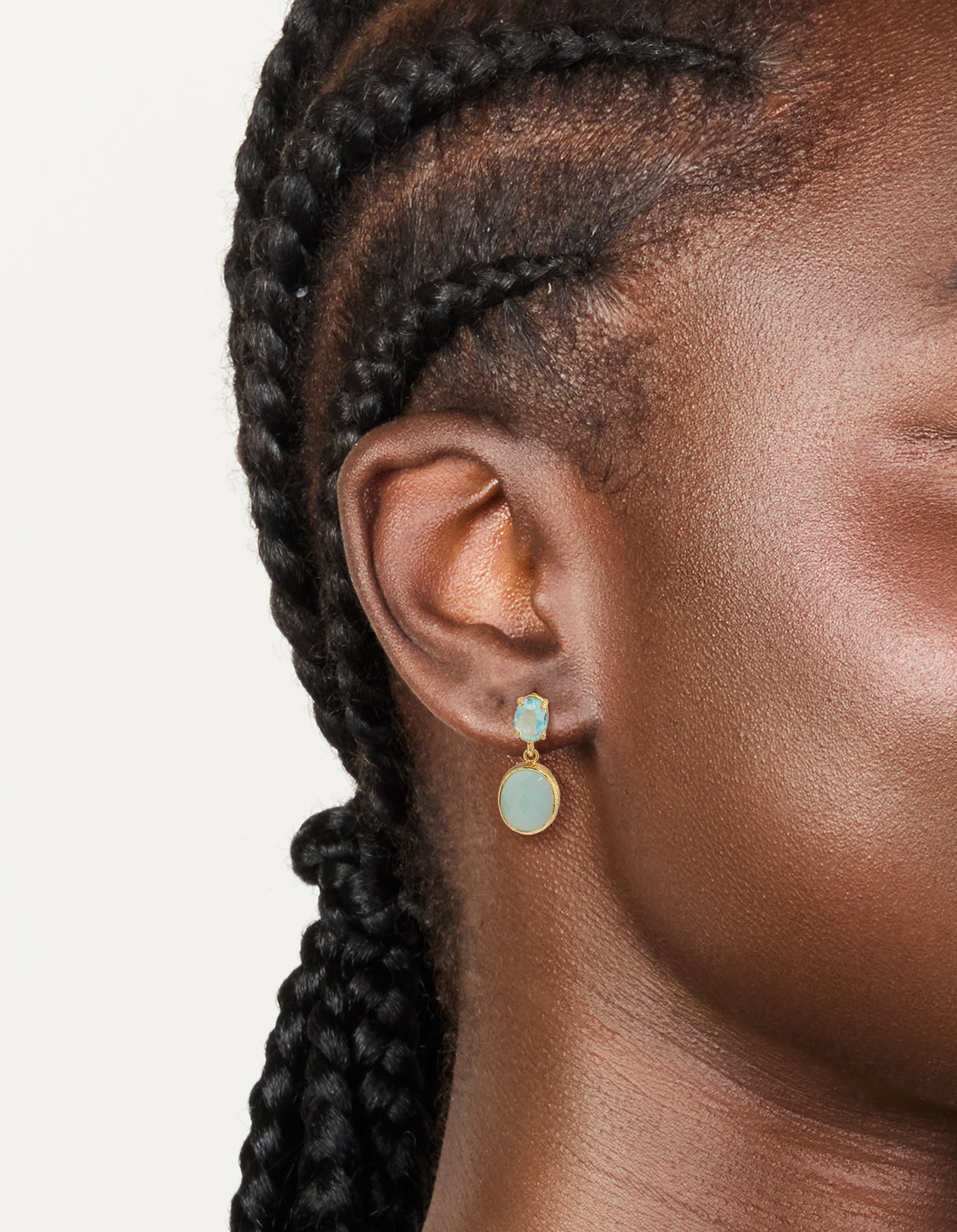 Elegant gold plated cubic zirconia blue double oval drop earrings featuring light turquoise stones on ear view