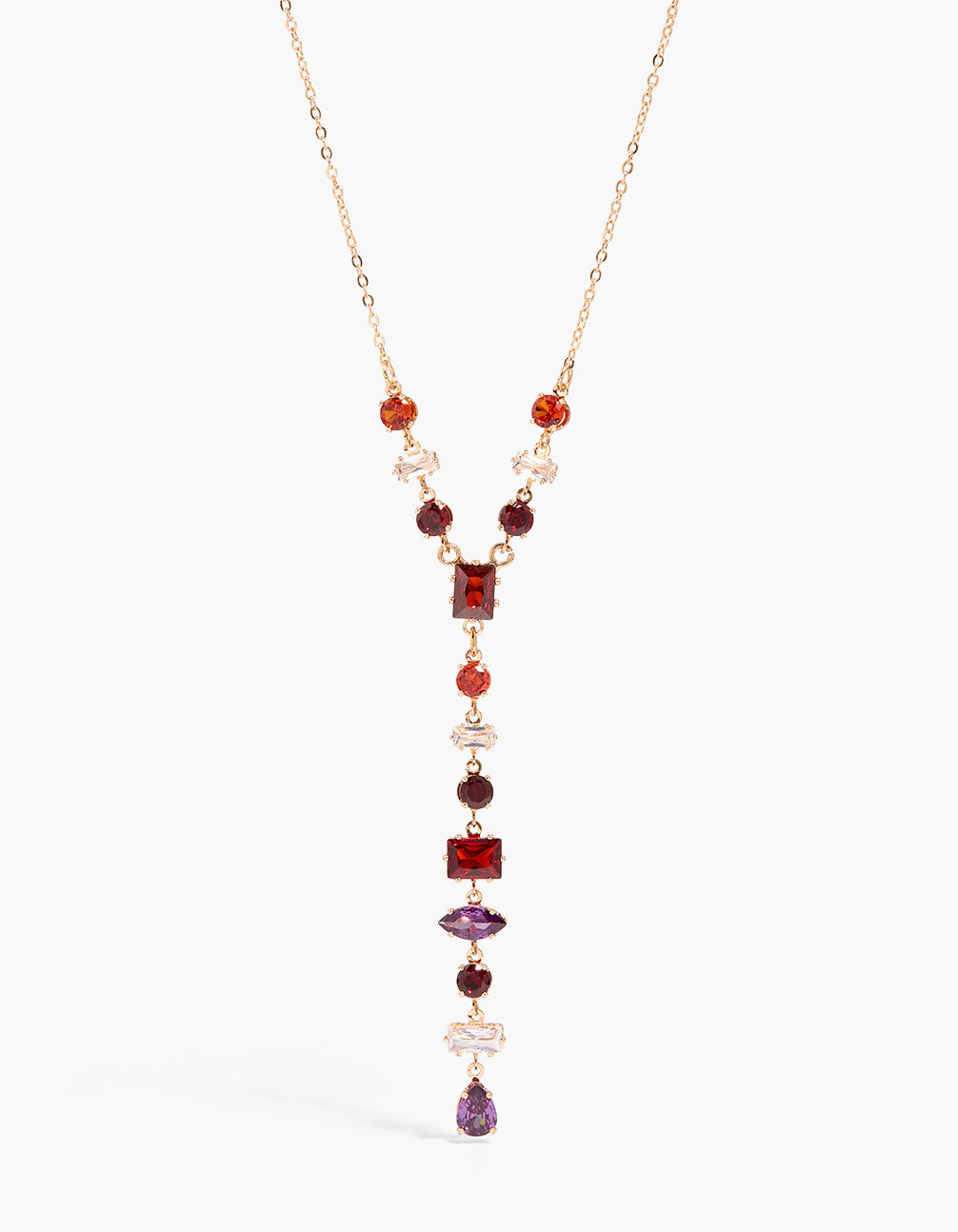 Showcasing a cubic zirconia statement necklace crafted from crystal in gold with red, purple, and white mismatched shaped stones close up view